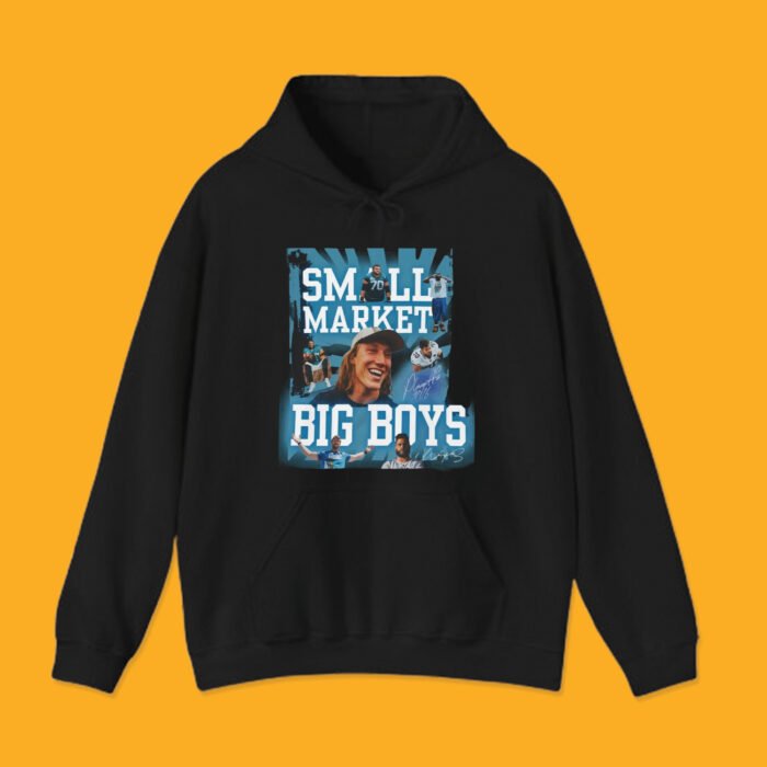 Black pullover hoodie with "Small Market Big Boys" viral sports design, showcasing Jacksonville quarterback Trevor Lawrence smiling.